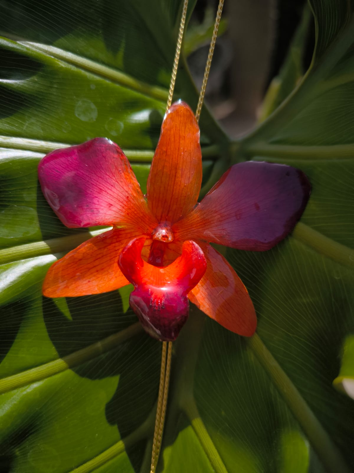 Collana con orchidea arancione e rosso porpora in resina, gioiello floreale artigianale luminoso