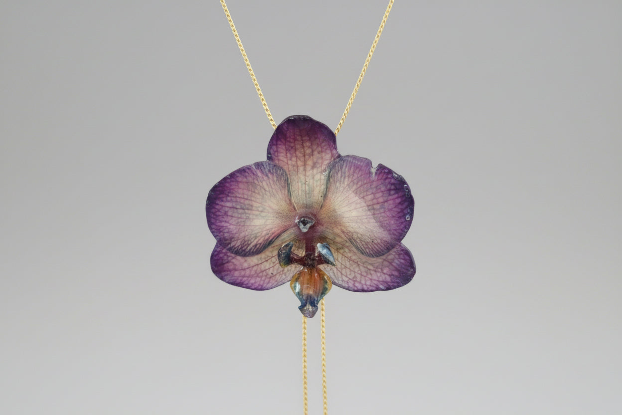 Collana orchidea Dendrobium iridescente con riflessi opalini in resina saliscendi oro