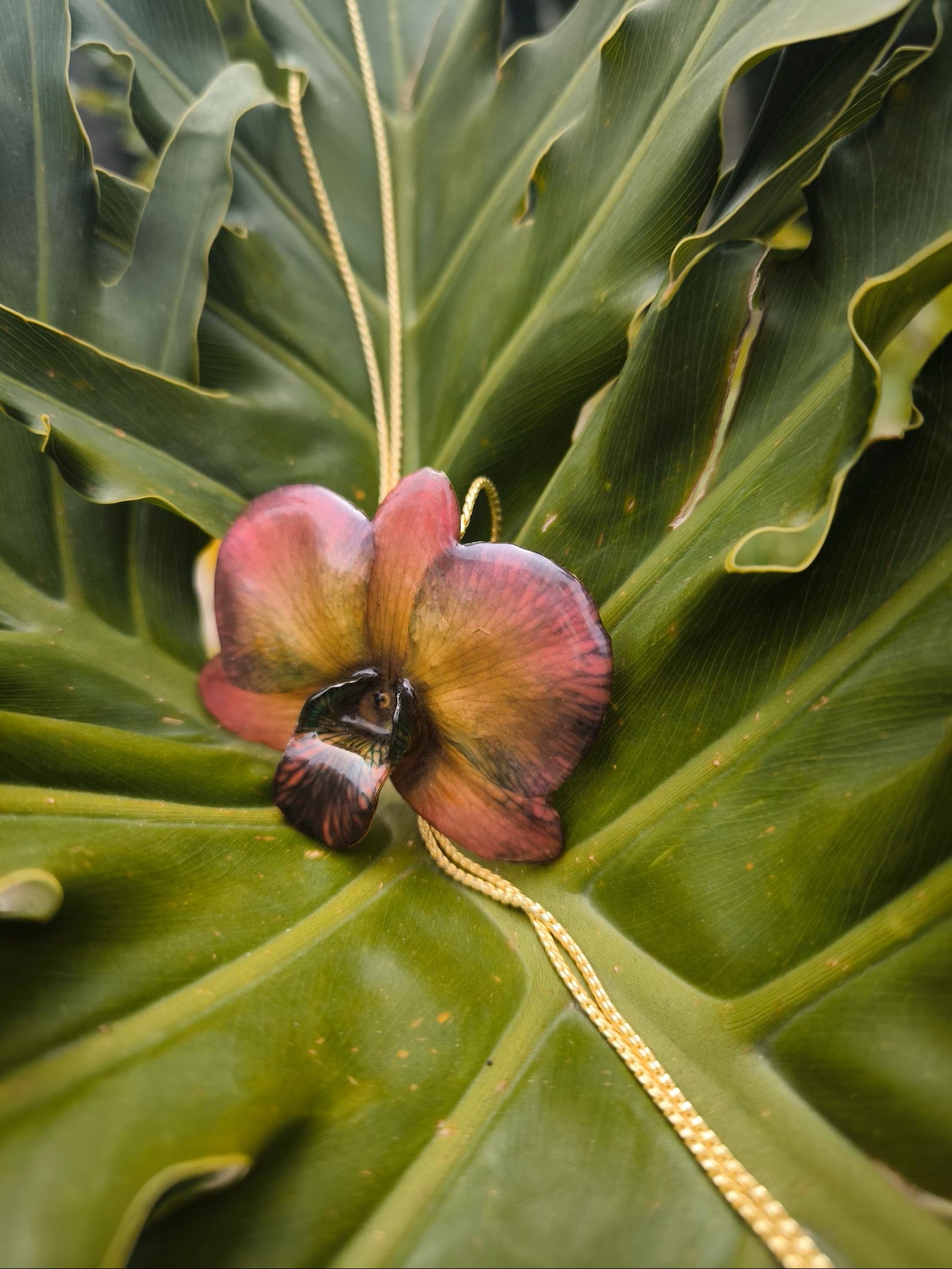 collana orchidea dendrobium marrone riflessi rossi azzurri resina saliscendi oro galvanizzato