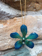 Collana con vera orchidea Mokara azzurra in resina e catenina in oro su bronzo.