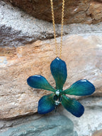 Collana con vera orchidea Mokara azzurra in resina e catenina in oro su bronzo.