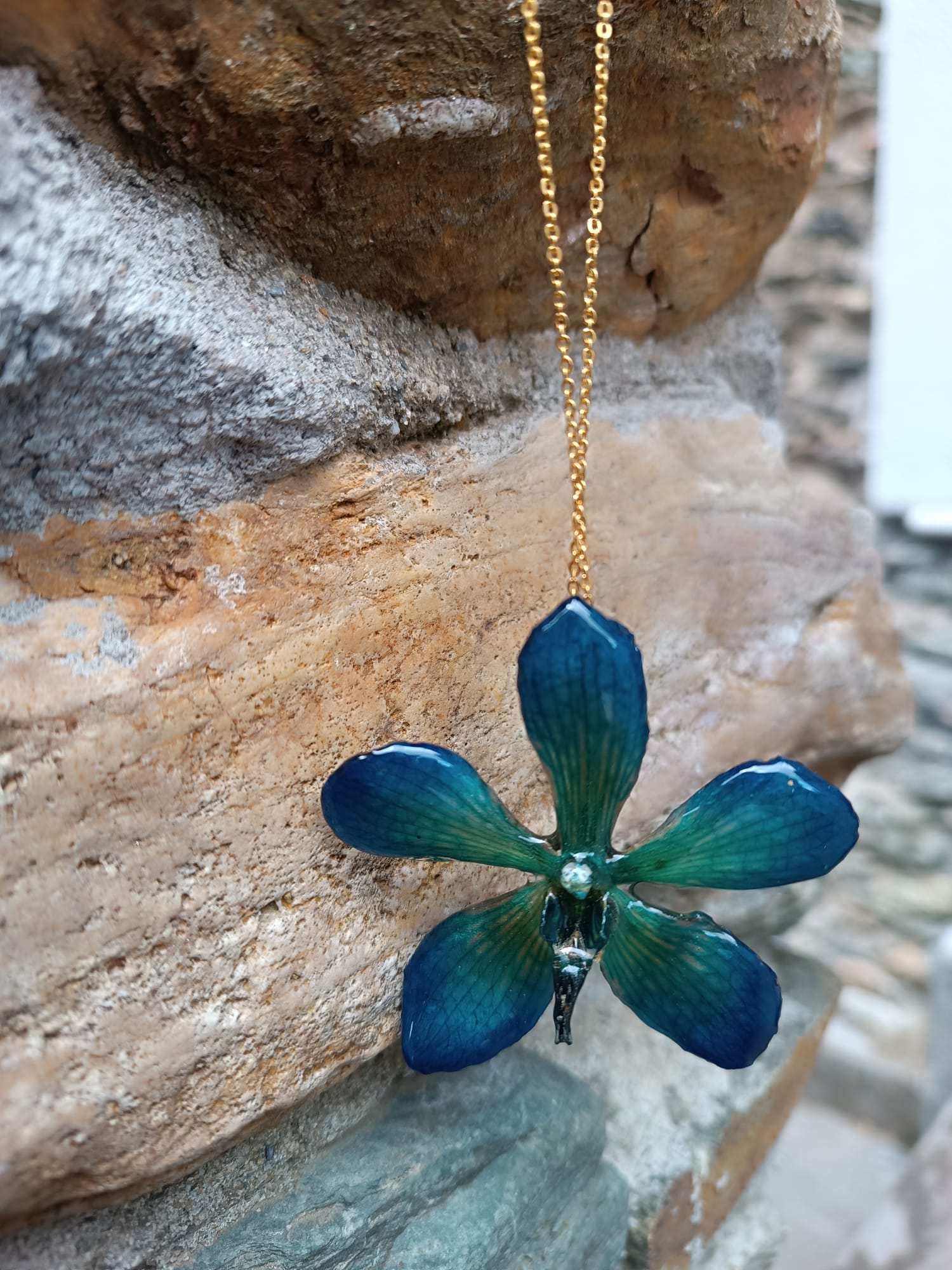 Collana con vera orchidea Mokara azzurra in resina e catenina in oro su bronzo.