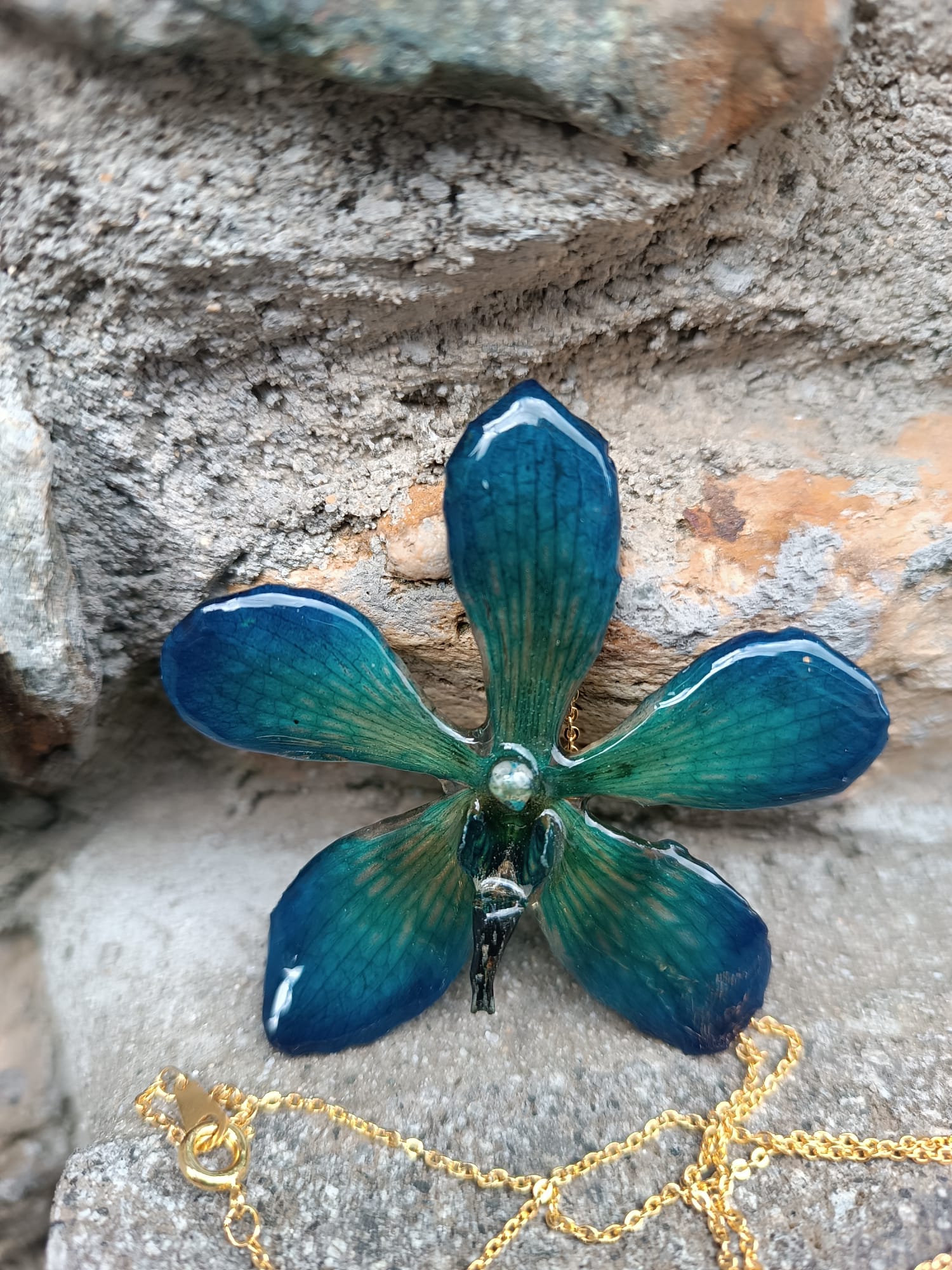 Collana con vera orchidea Mokara azzurra in resina e catenina in oro su bronzo.