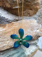 Collana con vera orchidea Mokara azzurra in resina e catenina in oro su bronzo.