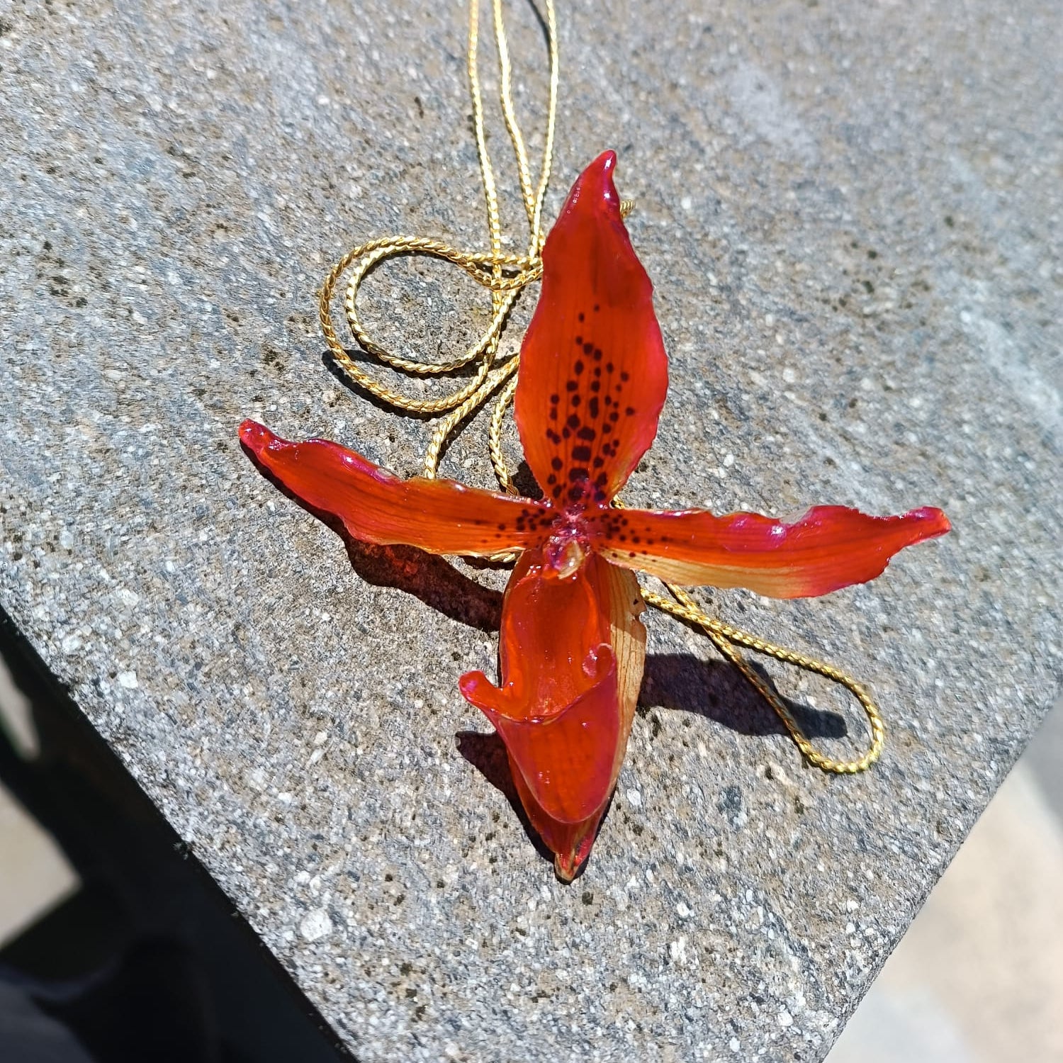 Collana saliscendi con orchidea rossa naturale inglobata in resina trasparente