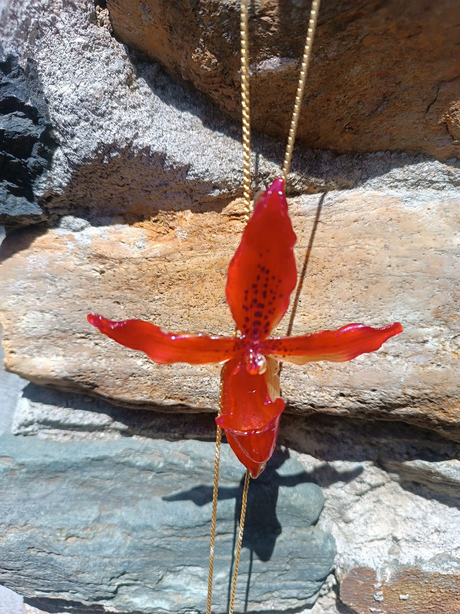 Collana saliscendi con orchidea rossa naturale inglobata in resina trasparente