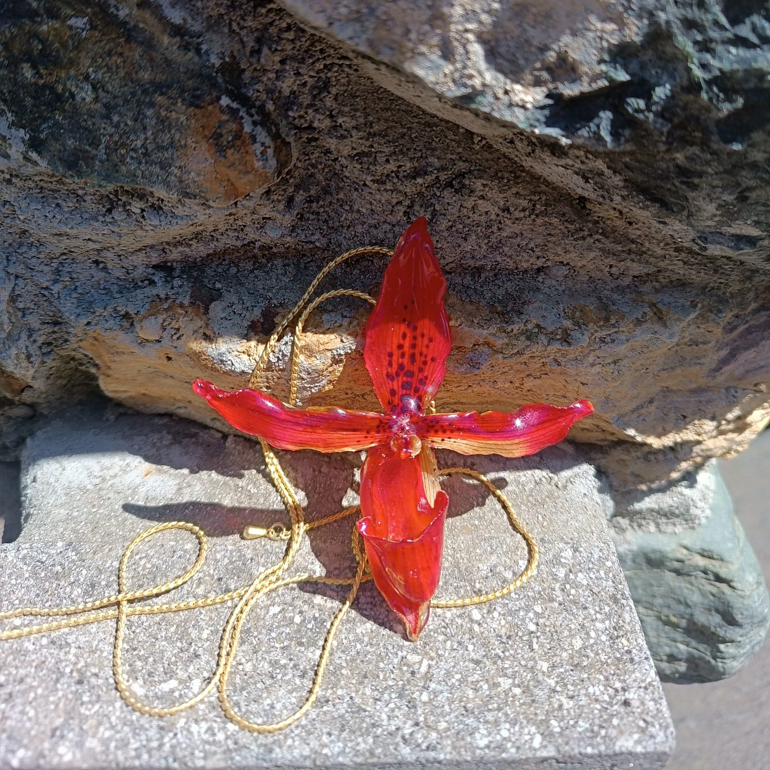 Collana saliscendi con orchidea rossa naturale inglobata in resina trasparente