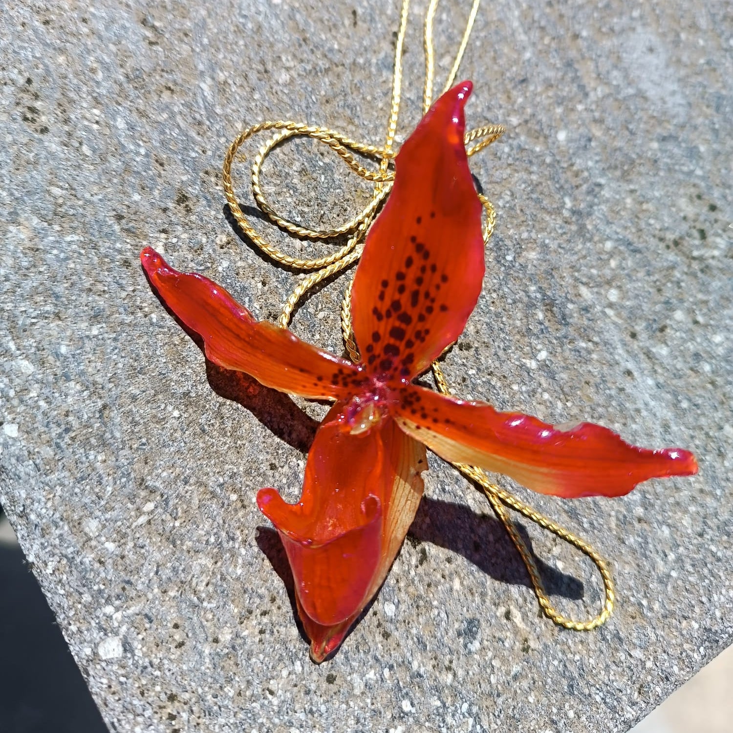 Collana saliscendi con orchidea rossa naturale inglobata in resina trasparente