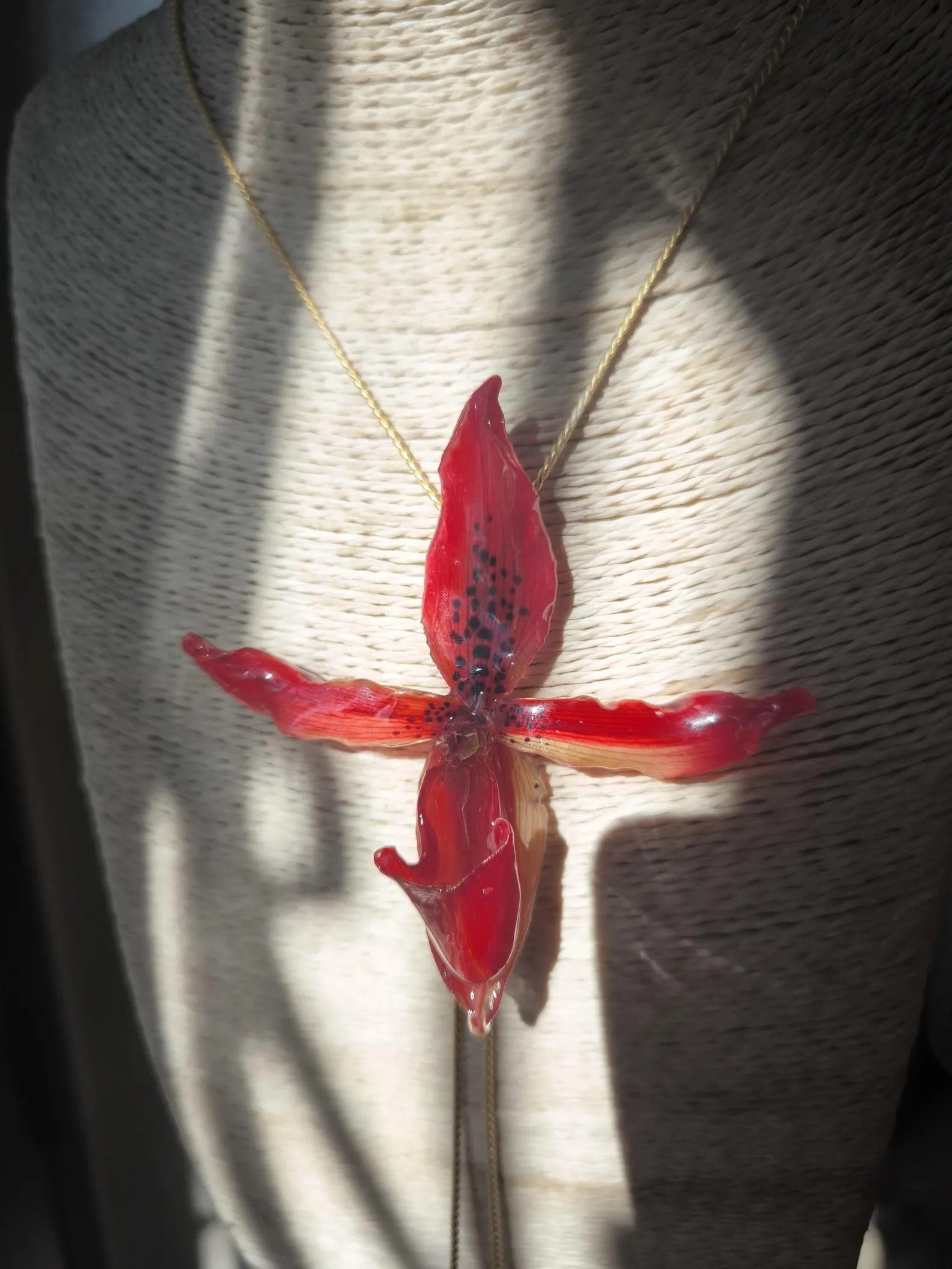 “Collana saliscendi con orchidea rossa naturale inglobata in resina trasparente”