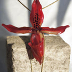 “Collana saliscendi con orchidea rossa naturale inglobata in resina trasparente”