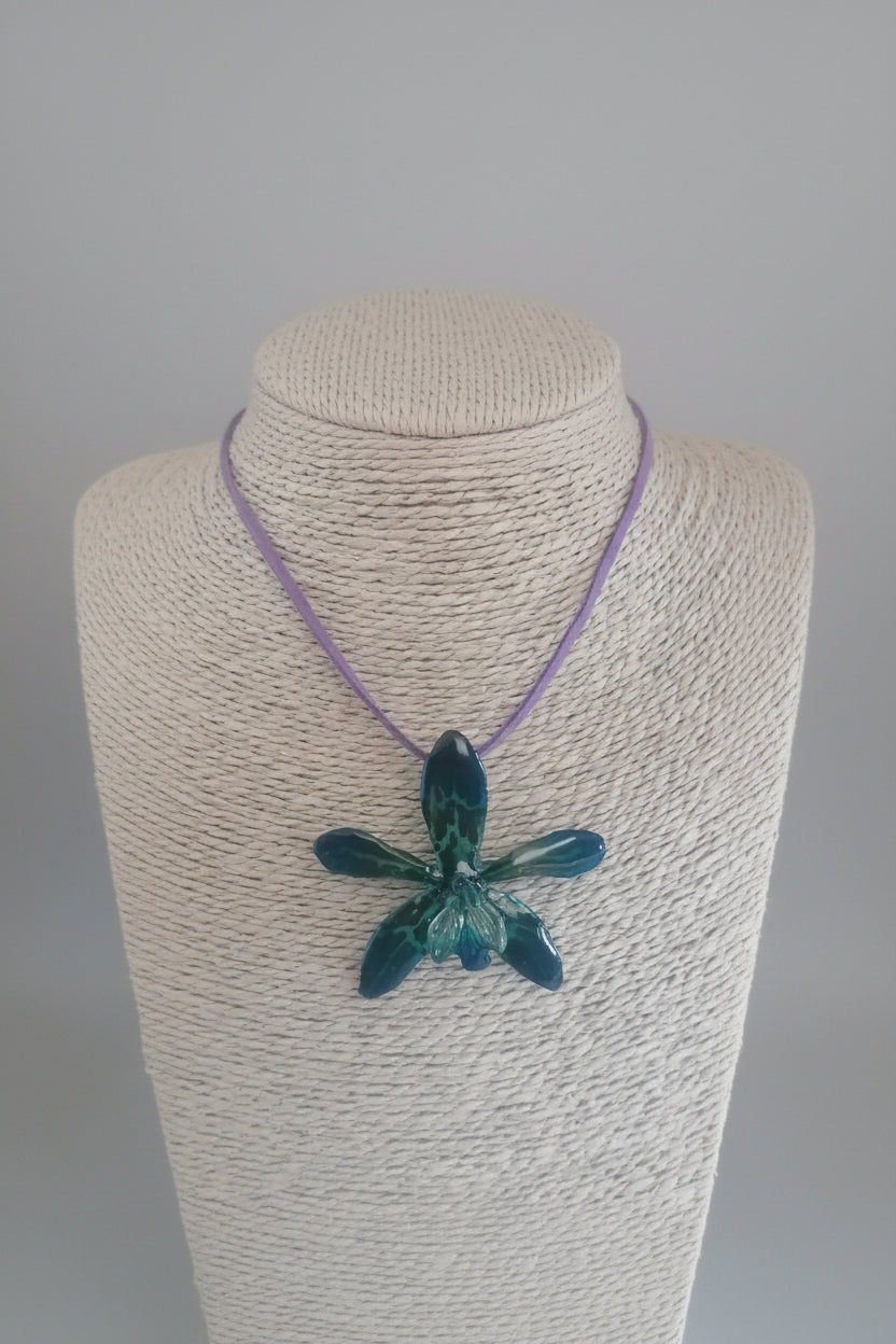 collana orchidea tiger azzurra resina riflessi verdi laccio pelle viola elegante rara
