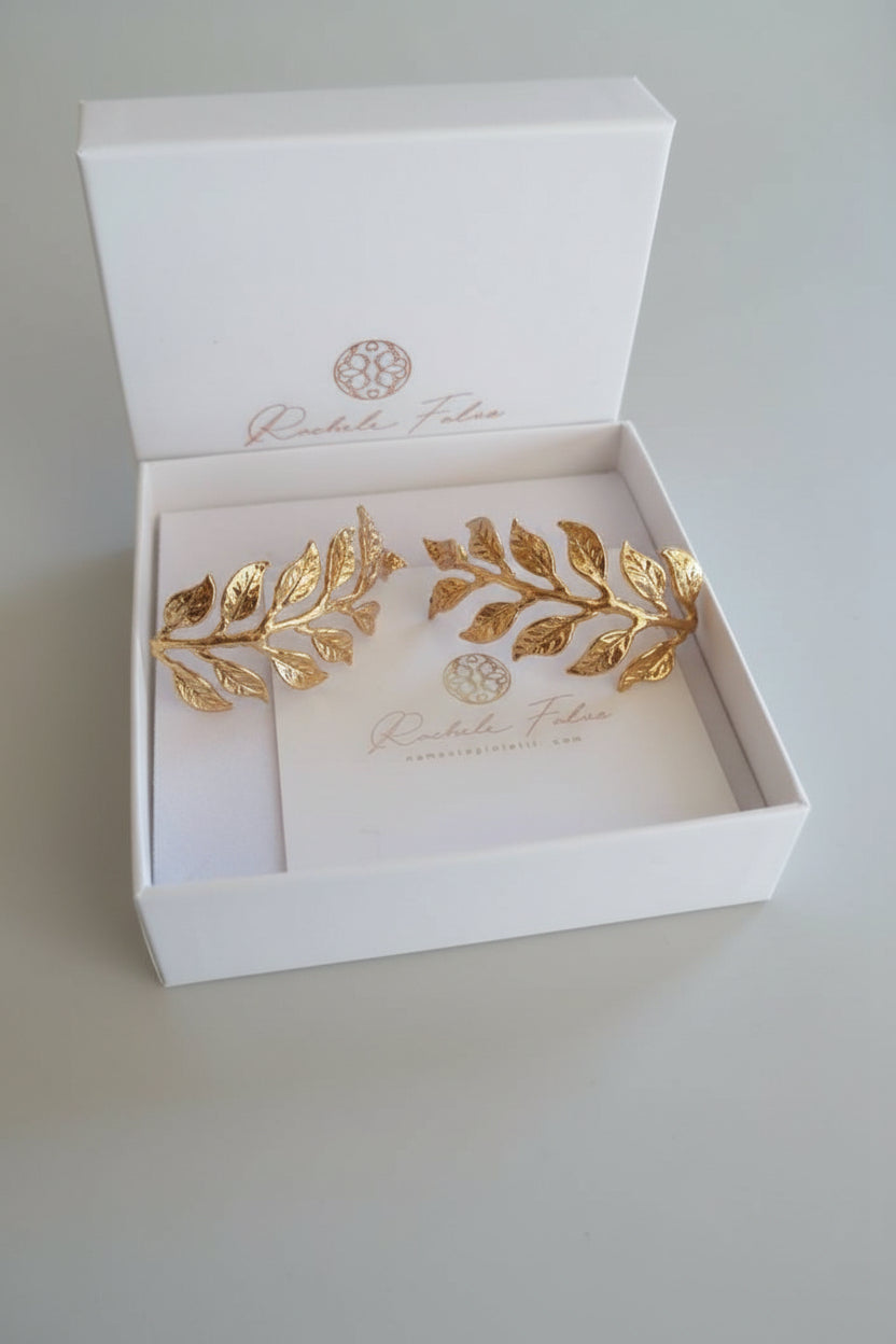 Orecchini dorati artigianali in oro su bronzo a forma di ramo fogliato con dettagli scolpiti, design elegante ispirato alla natura.