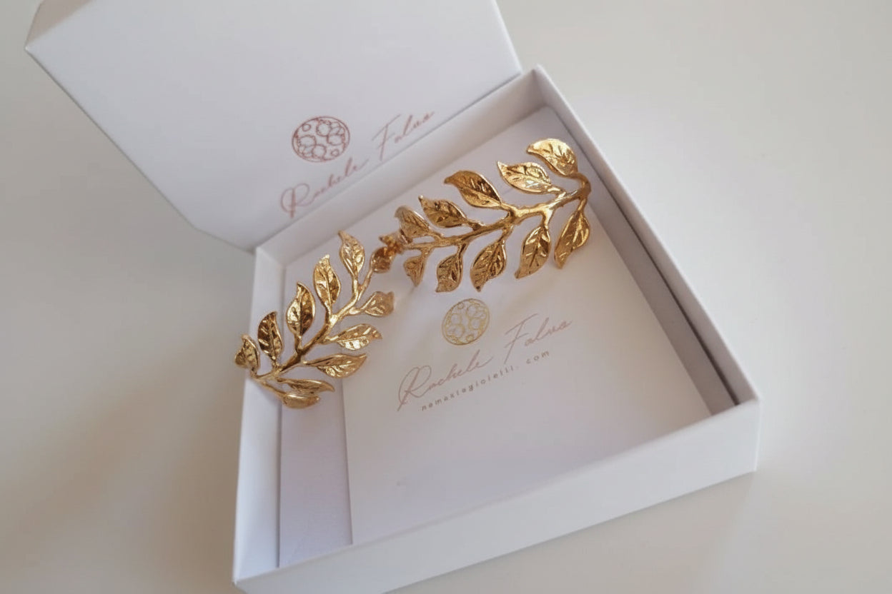 Orecchini dorati artigianali in oro su bronzo a forma di ramo fogliato con dettagli scolpiti, design elegante ispirato alla natura.
