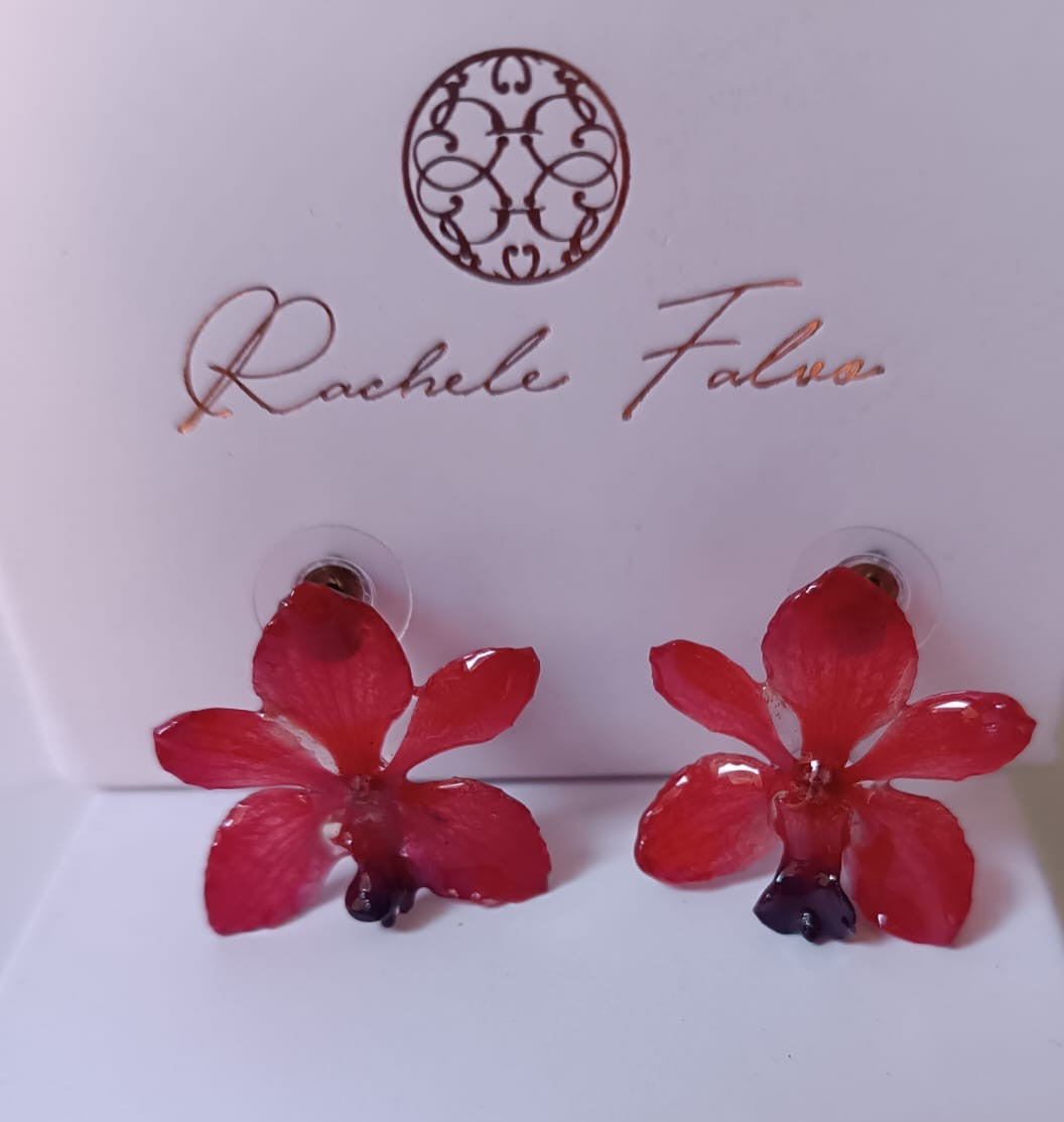 Coppia di piccoli orecchini artigianali al lobo a forma di orchidea vera di colore rosso intenso con sfumature viola al centro, inglobati in resina lucida