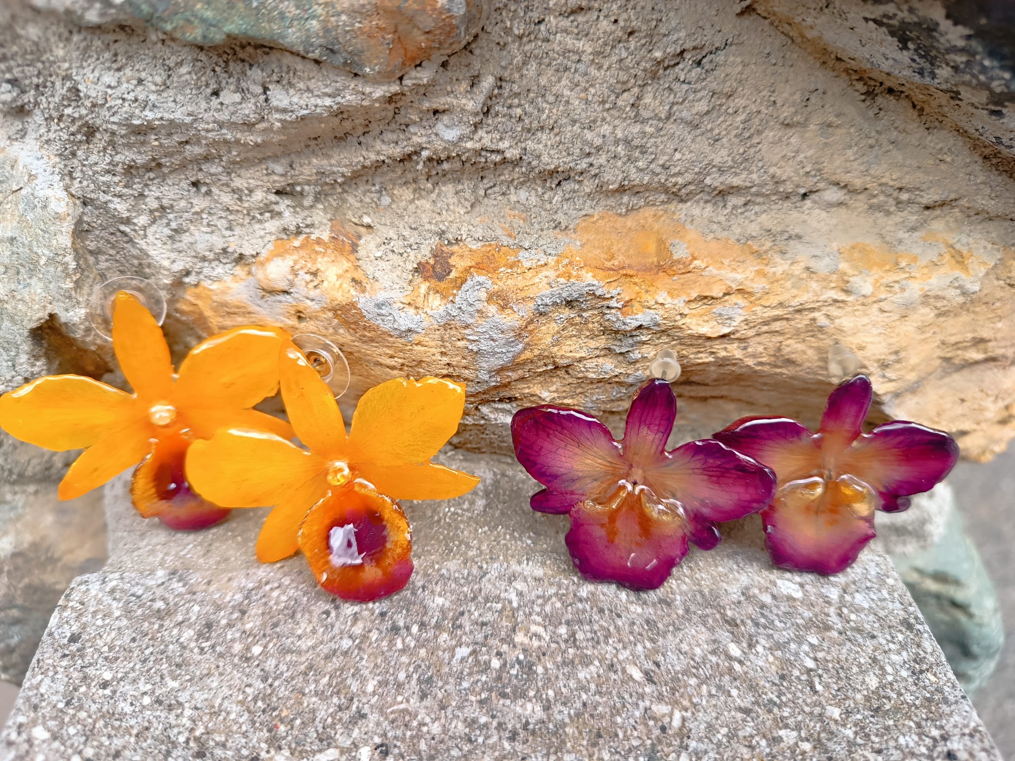 orecchini artigianali al lobo realizzati con intere orchidee vere in resina lucida, una variante  viola ed una giallo ocra con sfumature viola