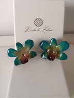 orecchini a lobo artigianali Rachele Falvo realizzati con intere orchidee vere 3D color azzurro verde turchese, teal e centro viola