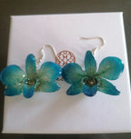 Orecchini con orchidee naturali azzurre inglobate in resina con ganci in argento