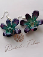 Orecchini con orchidee naturali turchese viola e rosa con venature visibili e chiusura in argento