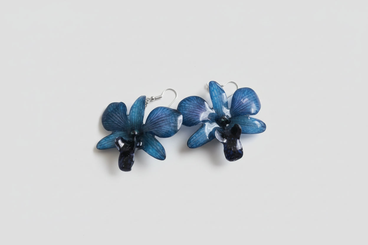 Orecchini con orchidee rare viola nere e blu inglobate in resina con venature lilla e tortora