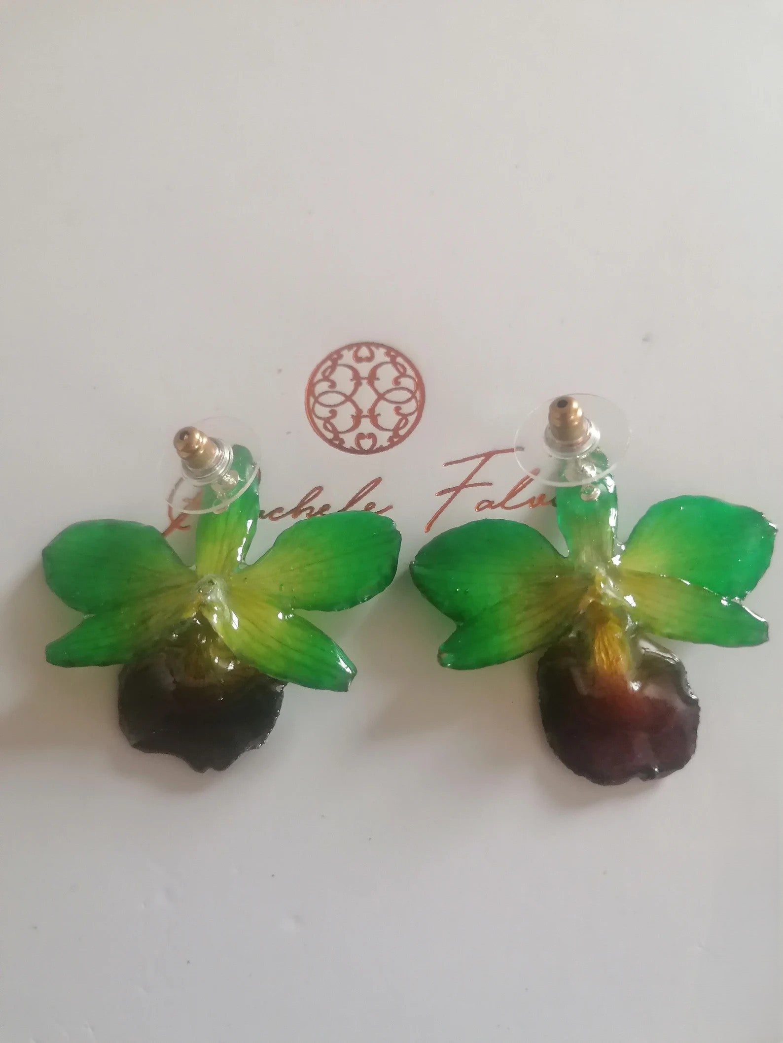 Orecchini con piccole orchidee naturali verdi con bocca viola in resina e ganci in argento
