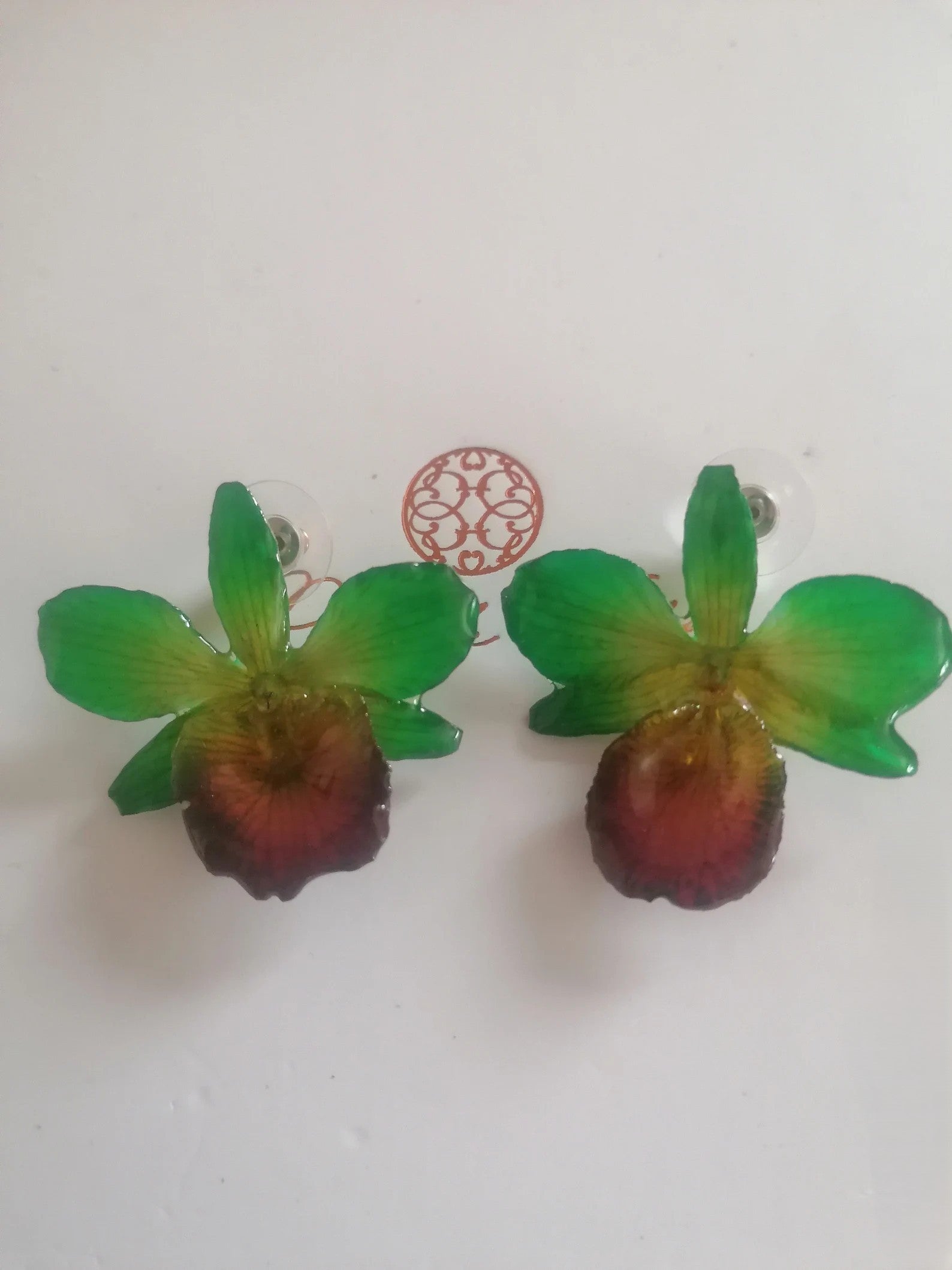 Orecchini con piccole orchidee naturali verdi con bocca viola in resina e ganci in argento