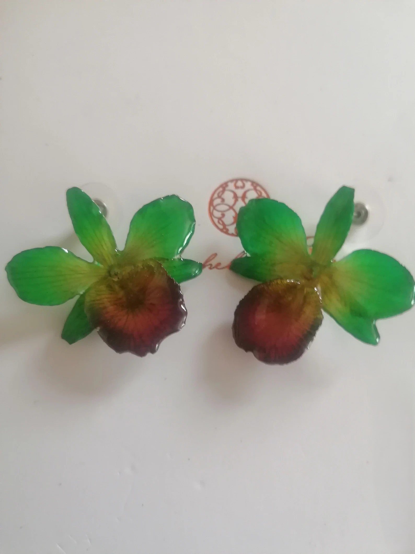 Orecchini con piccole orchidee naturali verdi con bocca viola in resina e ganci in argento