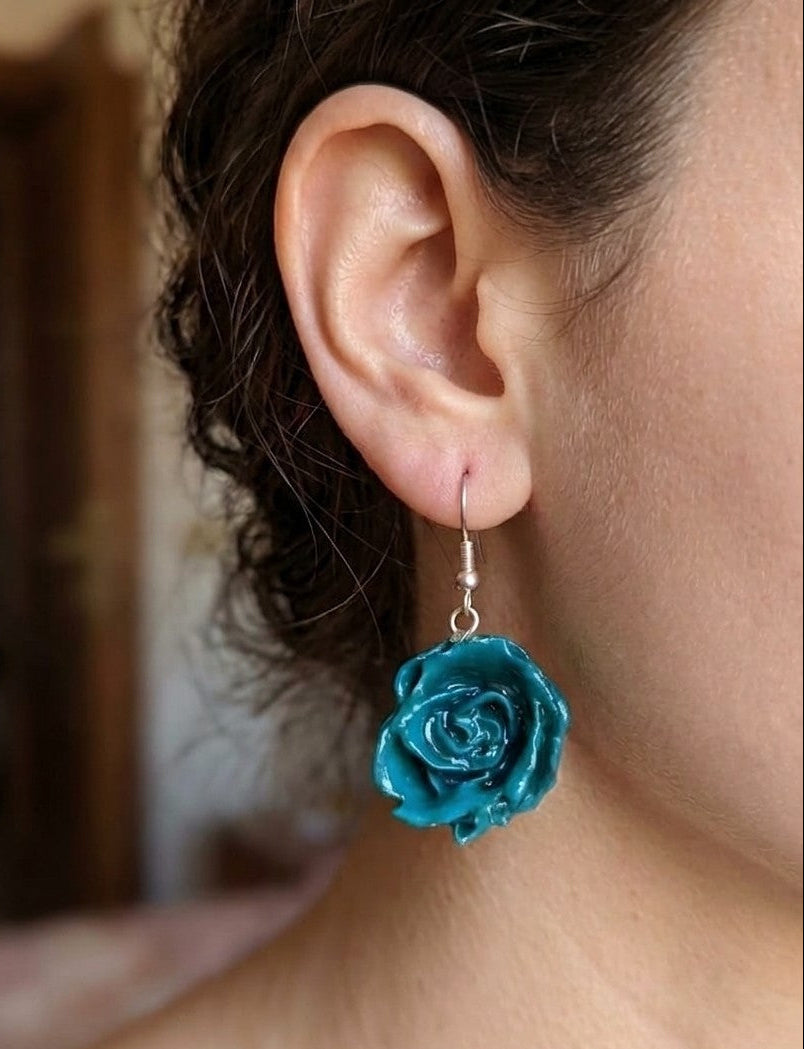 recchini pendenti artigianali Rachele Falvo realizzati con veri boccioli di rosa 3D in resina lucida e ganci d'argento, mostrati nei colori rosa antico, bianco, verde petrolio, arancio e fucsia
