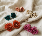 recchini pendenti artigianali Rachele Falvo realizzati con veri boccioli di rosa 3D in resina lucida e ganci d'argento, mostrati nei colori rosa antico, bianco, verde petrolio, arancio e fucsia