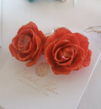 recchini pendenti artigianali Rachele Falvo realizzati con veri boccioli di rosa 3D in resina lucida e ganci d'argento, mostrati nei colori rosa antico, bianco, verde petrolio, arancio e fucsia