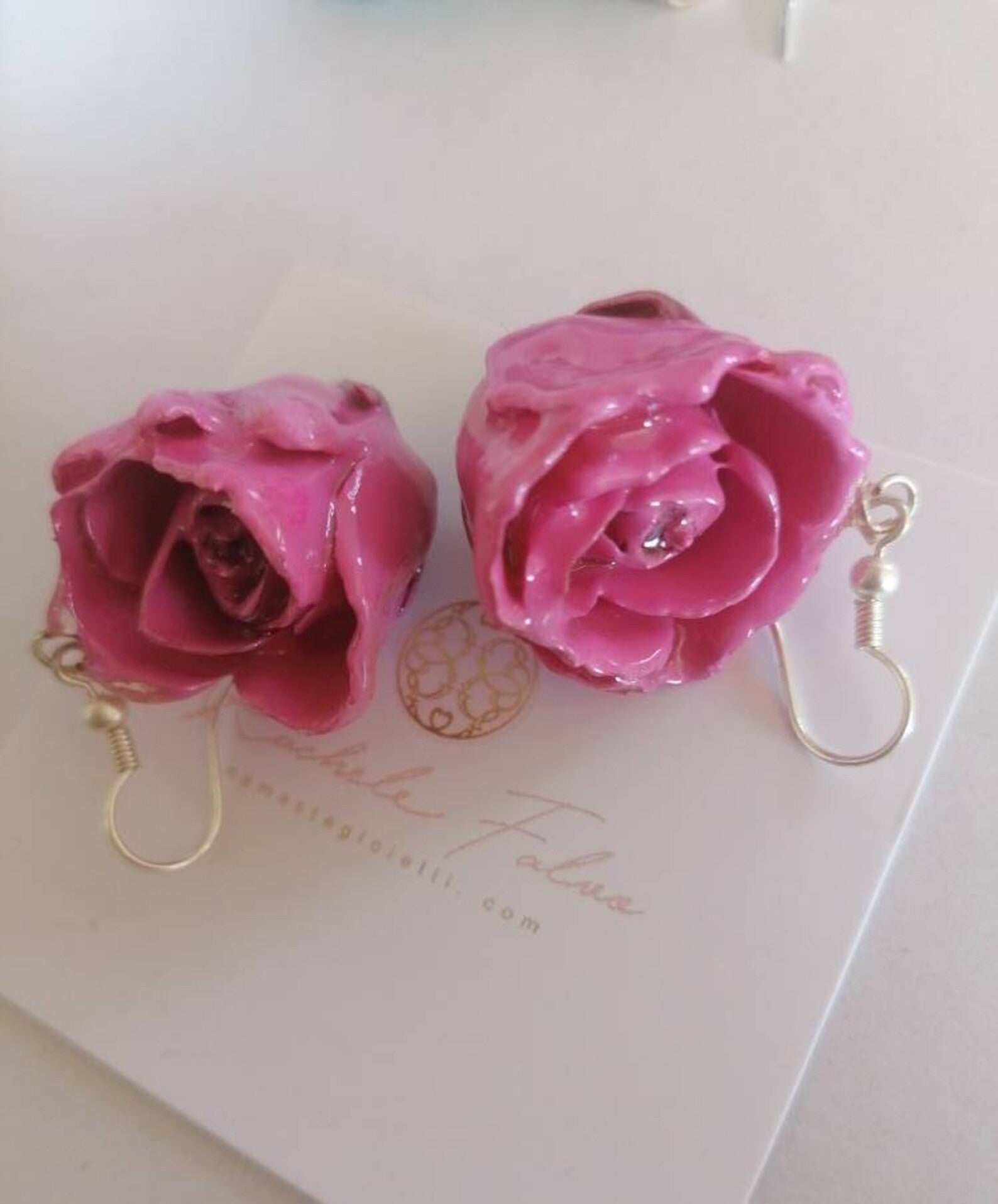 recchini pendenti artigianali Rachele Falvo realizzati con veri boccioli di rosa 3D in resina lucida e ganci d'argento, mostrati nei colori rosa antico, bianco, verde petrolio, arancio e fucsia