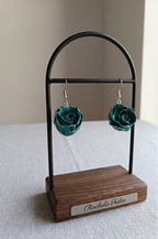 recchini pendenti artigianali Rachele Falvo realizzati con veri boccioli di rosa 3D in resina lucida e ganci d'argento, mostrati nei colori rosa antico, bianco, verde petrolio, arancio e fucsia