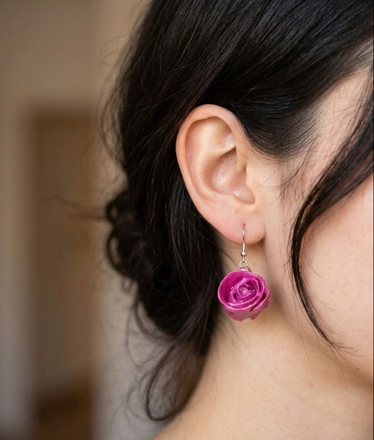 recchini pendenti artigianali Rachele Falvo realizzati con veri boccioli di rosa 3D in resina lucida e ganci d'argento, mostrati nei colori rosa antico, bianco, verde petrolio, arancio e fucsia