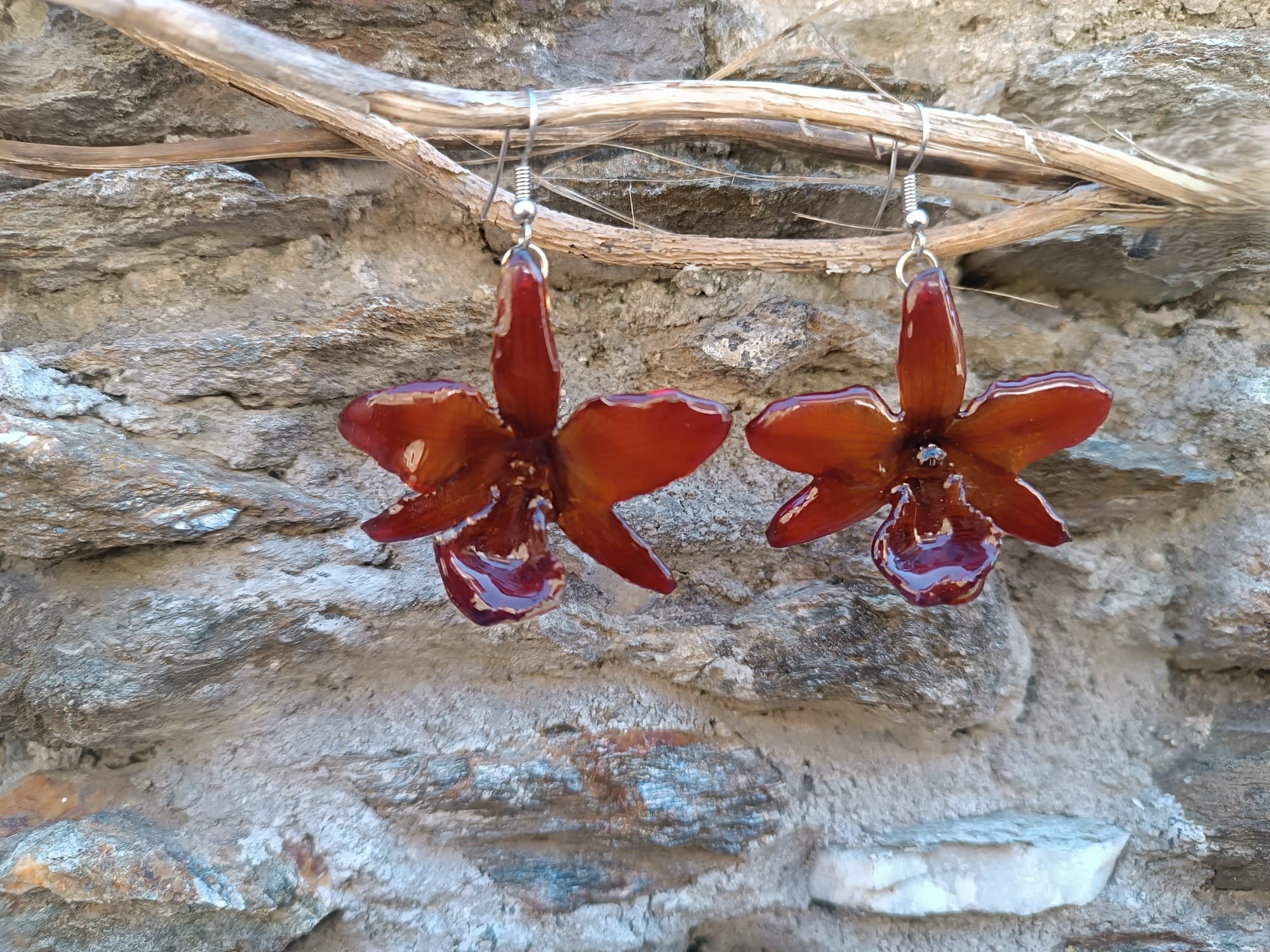 orecchini pendenti artigianali Rachele Falvo realizzati con intere orchidee vere sfumate in arancio ruggine, marrone terra di siena e bordeaux in resina lucida