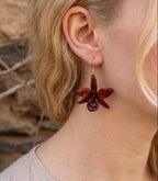 orecchini pendenti artigianali Rachele Falvo realizzati con intere orchidee vere sfumate in arancio ruggine, marrone terra di siena e bordeaux in resina lucida