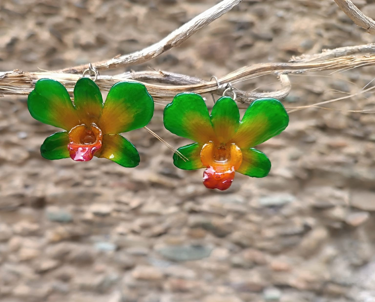 orecchini pendenti artigianali Rachele Falvo, realizzati con intere orchidee vere sfumate in verde brillante, giallo ocra e centro fucsia viola in resina lucida.