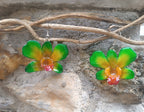 orecchini pendenti artigianali Rachele Falvo, realizzati con intere orchidee vere sfumate in verde brillante, giallo ocra e centro fucsia viola in resina lucida.