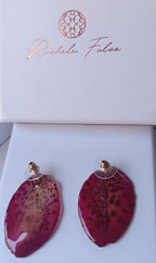 Orecchini a perno con chiusura a farfalla realizzati con petali veri di orchidea rosso amaranto dalla trama maculata, esposti sopra la loro scatola regalo bianca con logo Rachele Falvo.