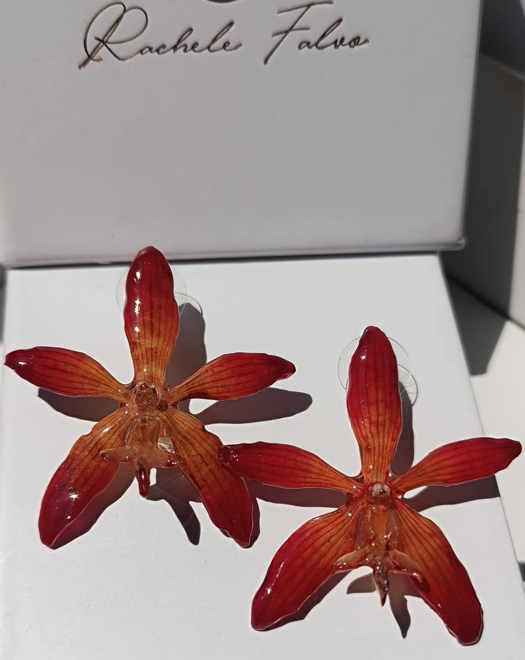 orecchini a perno artigianali Rachele Falvo realizzati con intere orchidee vere arancioni e panna in resina lucida