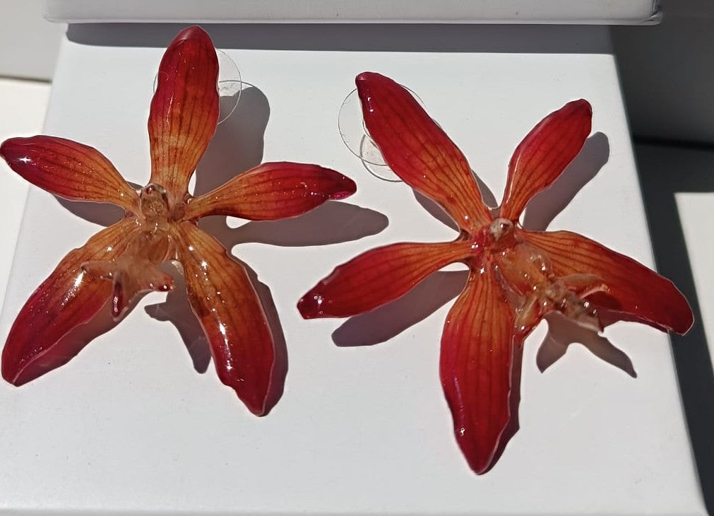 orecchini a perno artigianali Rachele Falvo realizzati con intere orchidee vere arancioni e panna in resina lucida