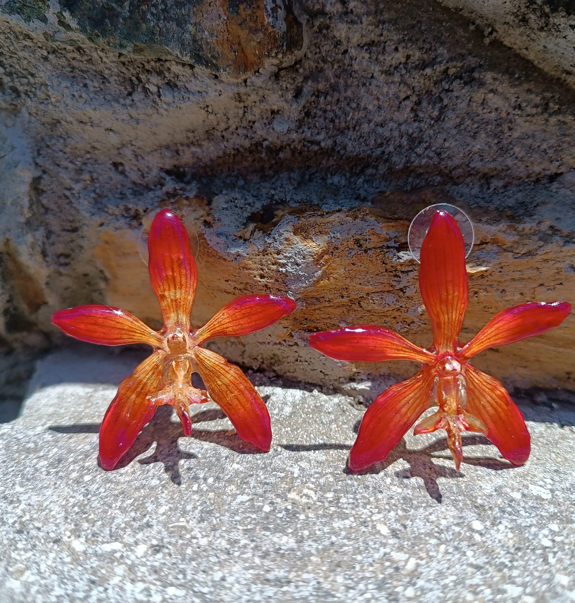orecchini a perno artigianali Rachele Falvo realizzati con intere orchidee vere arancioni e panna in resina lucida