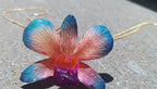 Collana con orchidea naturale azzurra e rossa inglobata in resina e saliscendi oro su bronzo regolabile