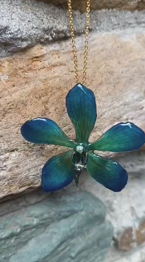 Collana con vera orchidea Mokara azzurra in resina e catenina in oro su bronzo.